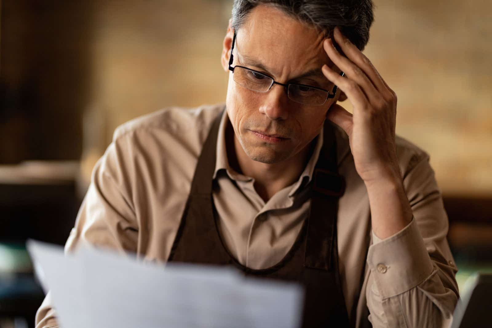 Man looking confused at a piece of paper 