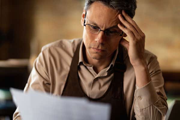 Man looking confused at a piece of paper