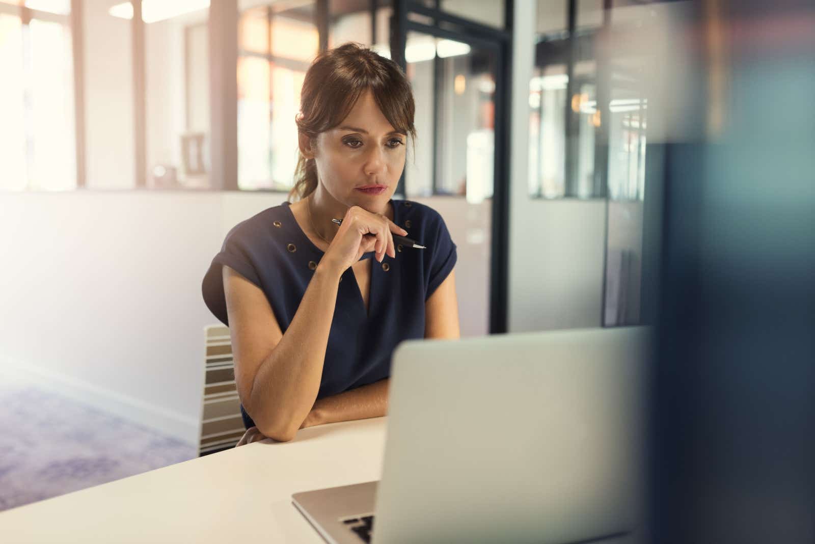 Focussed business woman looking at her laptop screen.